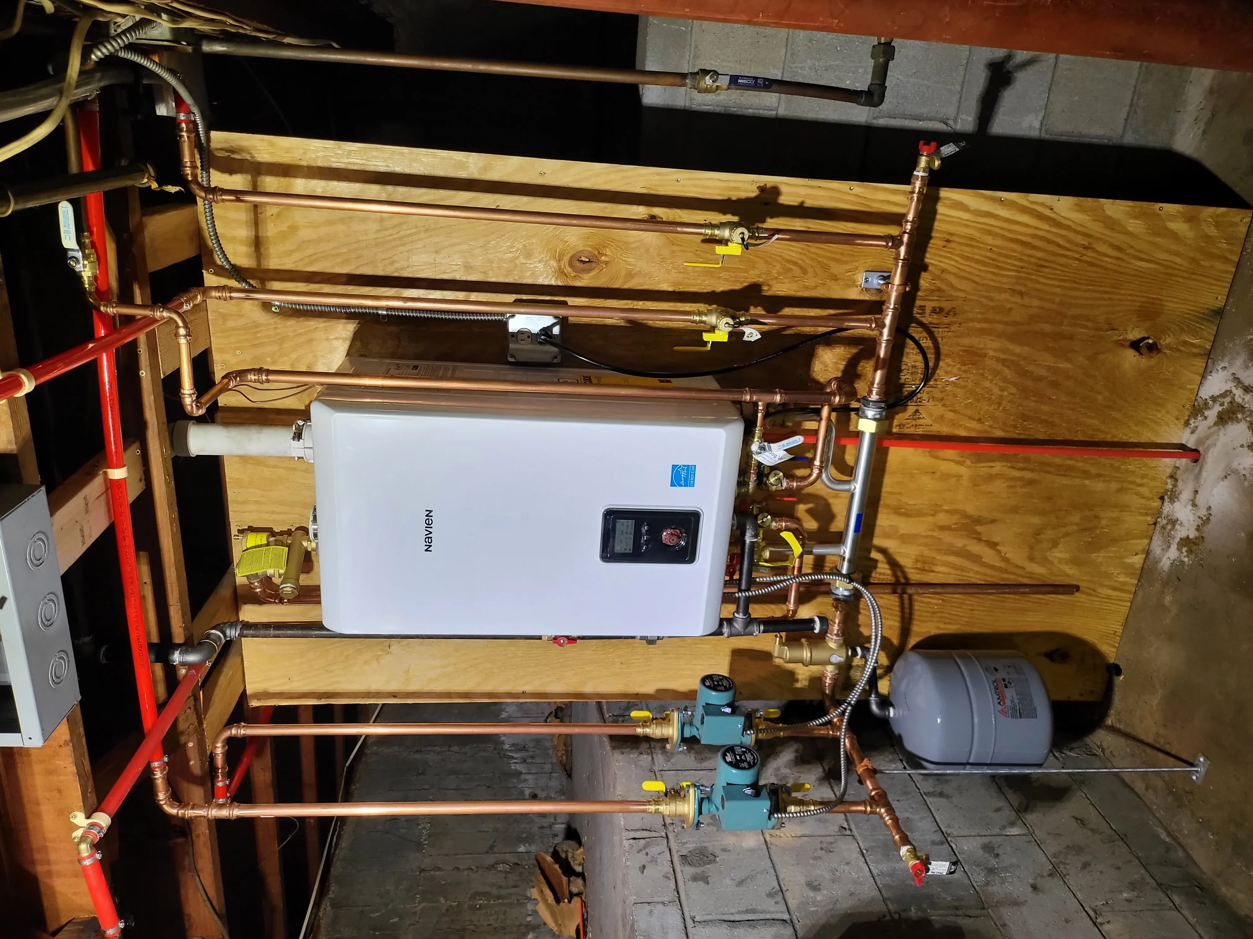 Tankless water heater with copper piping, mixing valves, and expansion tank installation