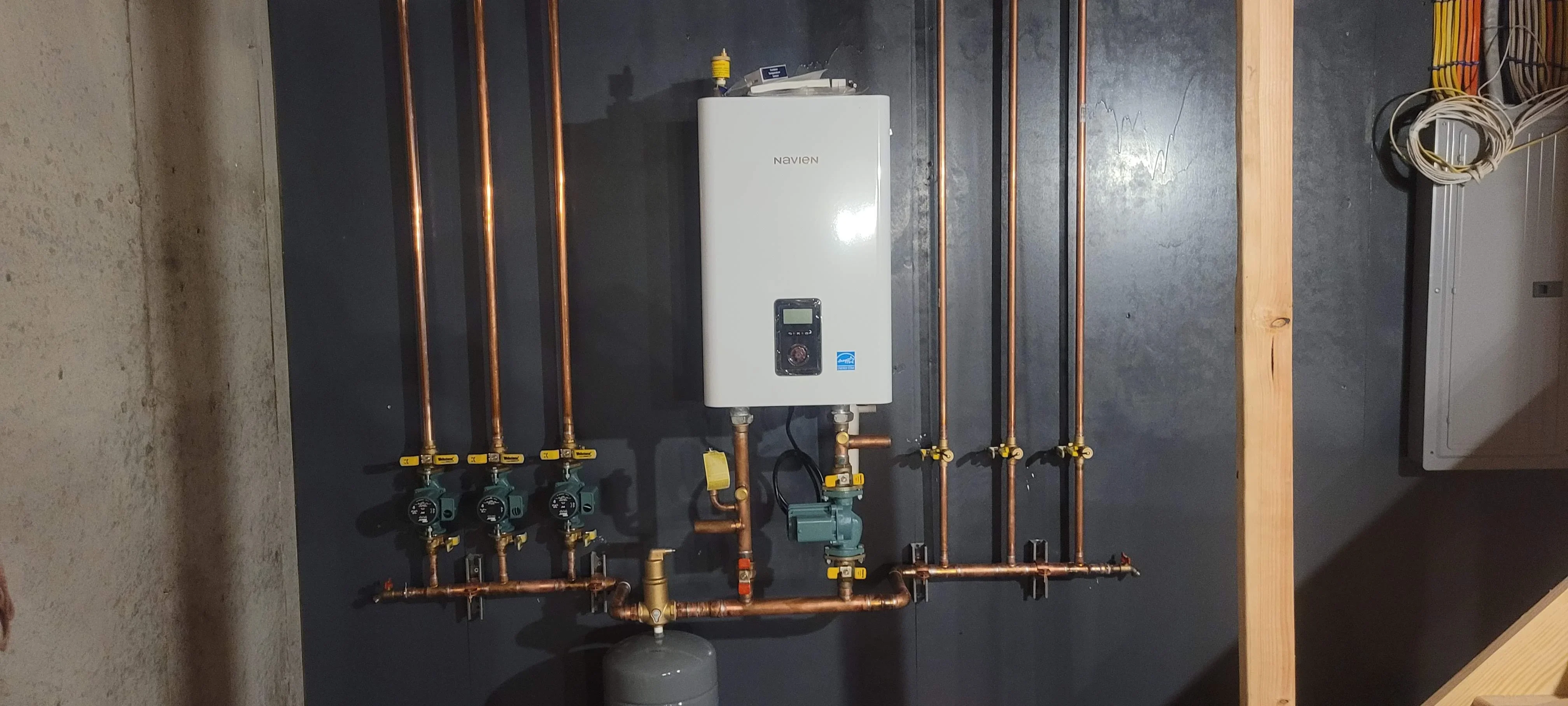 Navien tankless water heater with three-zone radiant heating manifold and copper piping installation